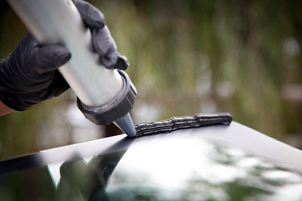 Professional auto glass technician inspecting a newly installed windshield